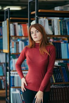 A girl holding a book shelf. High quality photo. Student in the library