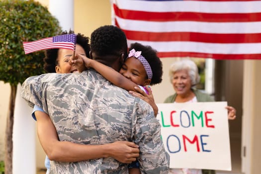 African american military soldier embracing woman and daughter at entrance. family, bonding and patriotism, unaltered.