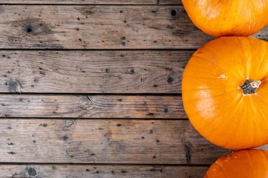 Composition of halloween decoration with pumpkins and copy space on wooden background. horror, fright, halloween tradition and celebration concept digitally generated image.