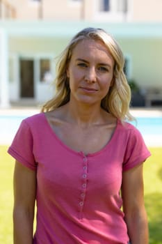 Portrait of caucasian young woman while standing in the garden. people and emotions concept, unaltered.