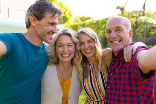 Portrait of two generation caucasian family taking selfie together in the garden. family, togetherness and weekend lifestyle concept, unaltered.