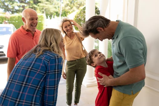 Caucasian couple welcoming their family at the entrance of the house. family, love and togetherness concept, unaltered.