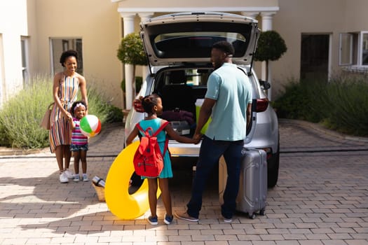 Happy african american family loading luggage in car trunk while going for picnic. unaltered, family, lifestyle, transportation, childhood, leisure activity and weekend activities.