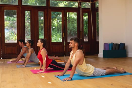 Men and women practicing yoga pose during exercise class at health club. healthy lifestyle, fitness and yoga.