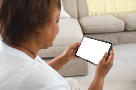 African american senior woman using digital tablet with copy space at home. lifestyle, wireless technology and advertisement.