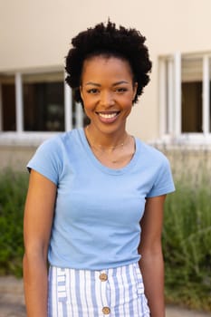 Portrait of happy african american young afro woman smiling while standing outdoors. people and emotions concept, unaltered.