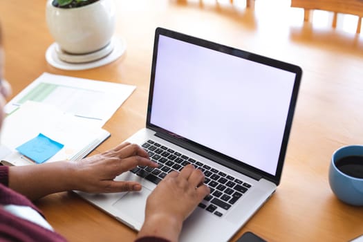 Cropped image of senior woman using laptop during online doctor consultation at home, copy space. lifestyle, wireless technology, telemedicine and healthcare.