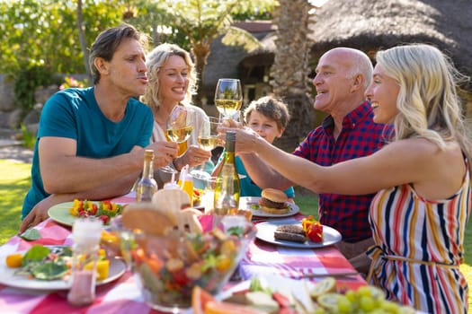 Caucasian three generation family toasting drinks in the garden. family, togetherness and weekend lifestyle concept, unaltered.