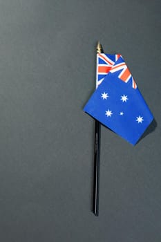 Overhead view of stars and union jack on australia flag stick by copy space over black table. patriotism, symbol and identity.