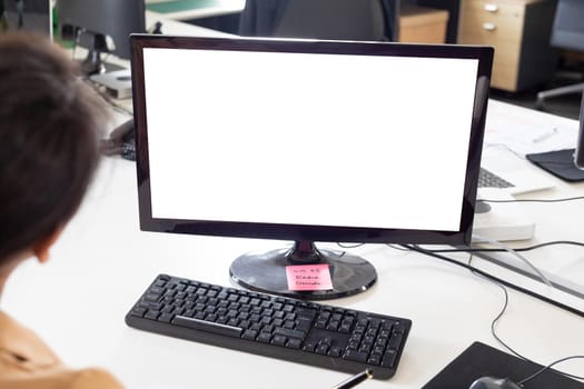 Cropped image of businesswoman with blank computer monitor at desk in office, copy space. unaltered, creative business, advertisement and technology concept.