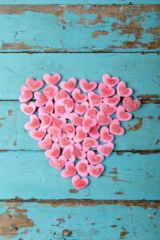 Overhead view of heart shaped pink candies arranged on wooden table, copy space. valentine's day, sweet food and love concept.