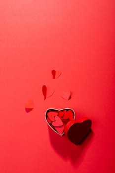 Directly above view of heart shaped decoration and gift box on red background, copy space. valentine's day and love concept.