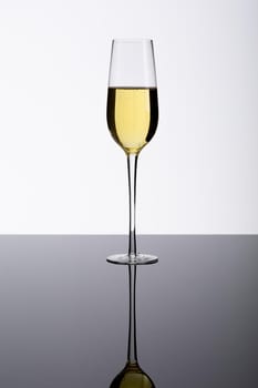 Champagne flute on glass table isolated over white background, copy space. drink, celebration and studio shot.