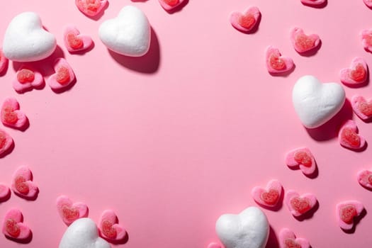 Heart shaped candies over pink background with copy space. valentine's day, food and love concept.