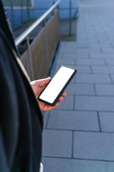 young business man looking phone near to office. Natural light in a sunny day. Smartphone with white screen to paste anything