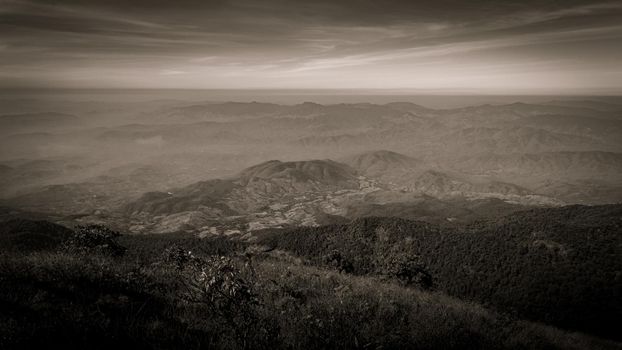 Beautiful landscape silhouette on the mountain peak during sunset with warm sunlight and dramatic sky. vintage tone