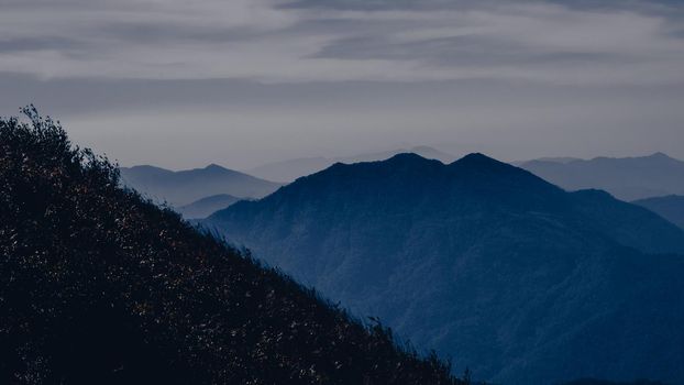 Beautiful landscape silhouette on the mountain peak during sunset with warm sunlight and dramatic sky.