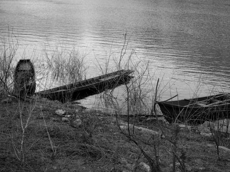 Two old wooden boats moored on the banks of the river. vintage tone