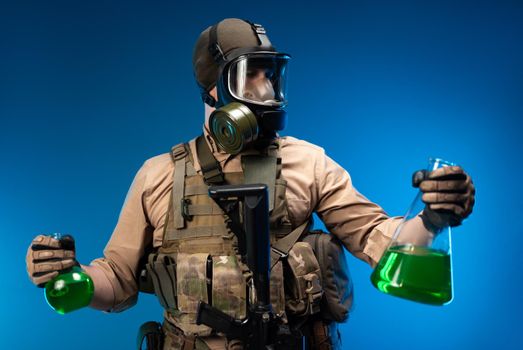 a man in military clothes and a gas mask with laboratory chemical flasks