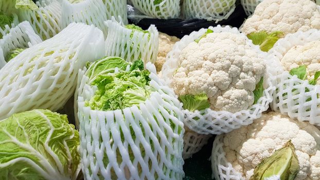 The cauliflower and green cabbage are wrapped in bubble wrap.