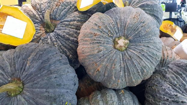 Several pumpkins were placed on the shelf. Some pumpkins were cut in half and had a white label attached to them.