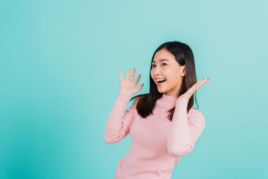 Happy young Asian beautiful woman smiling wear silicone orthodontic retainers on teeth surprised she is excited screaming and raise hand make gestures wow, studio shot isolated on blue background