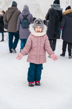child happy at ice sculpture festival on winter day