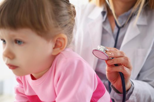 Portrait of little girl being examined by pediatrician female, calm child patiently waiting on appointment. Medical, healthcare, childhood, checkup concept