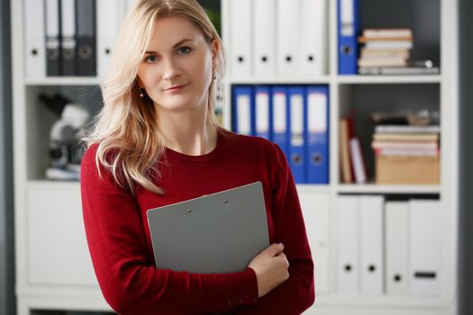 Portrait of lovely businesswoman stand with folder in presentable suit, smiling secretary work in big corporation. Business, office life, success concept