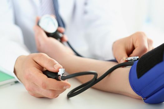 Close-up of doctor check blood pressure of patient in clinic, risk of hypertension, prevent disease. Work with stethoscope tool. Medicine, health concept