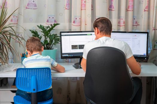 Father with kid trying to work from home during quarantine. Stay at home, work from home concept during coronavirus pandemic