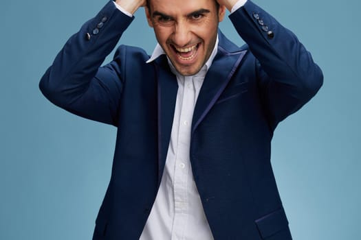 emotional man wearing a blue business suit and holding his head with his mouth open cropped copy-space view. High quality photo