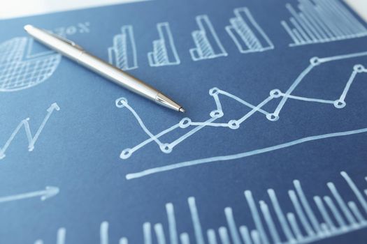 Ballpoint pen lying on document with graphs and charts on blue paper closeup. Statistical indicators of monetary profit in business concept