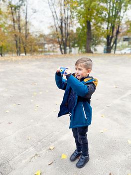 Passion for photography and children. Five-year-old boy in the park taking pictures of nature