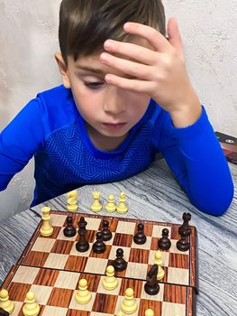 Children and chess. Five year old boy playing chess