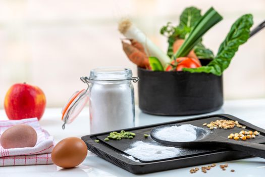 Bicarbonate surrounded by fruits and vegetables on a white background, view from above