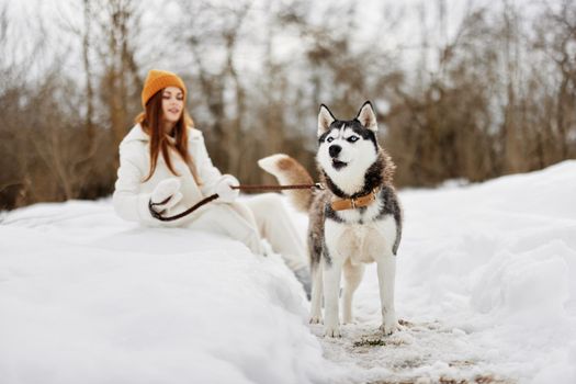 young woman outdoors in a field in winter walking with a dog Lifestyle. High quality photo