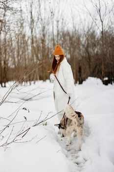 young woman in the snow playing with a dog outdoors friendship winter holidays. High quality photo