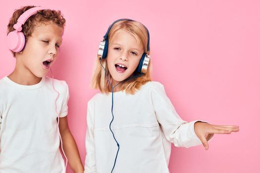 boy and girl stand next to in headphones lifestyle childhood. High quality photo