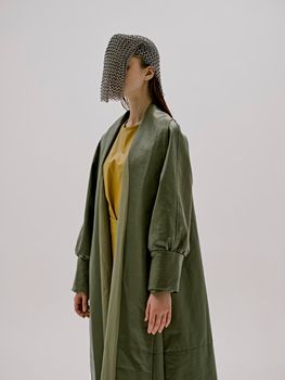 photo pretty woman in a green coat with chain mail on his head unaltered. High quality photo