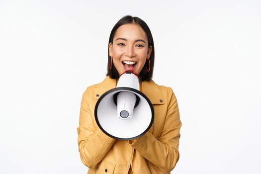 Attention announcement. Image of asian woman shouting in megaphone, recruiting, searching people, sharing information, standing over white background.