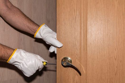a man repairs a house door lock. High quality photo