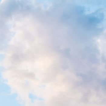 Background of blue sky with white and pink clouds at sunset