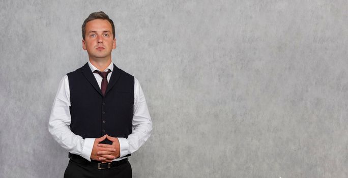 Portrait of a concerned boss. . Light studio background. A serious and pensive man of 30-35 years old stands against a light background.