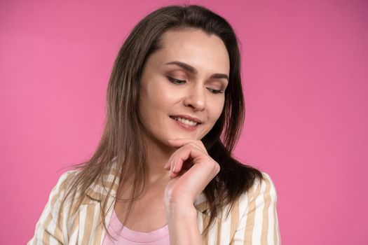 Suffering of headache or migraine young woman in sleeveless pink t-shirt holding her head with eyes shut isolated on pink background. Stressed employee woman in stripe suit. With copy space.