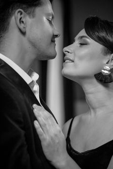 Portrait of beautiful young couple in home interior.Romance in relationships, love and tenderness. Husband and wife after a romantic dinner. Black and white photo.