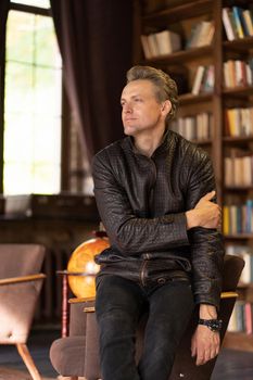 Pensive Man Looks to the Side and Enjoys the Silence. He is Lonely in His Big Old House. Close-up Portrait. Vintage Background. High quality photo