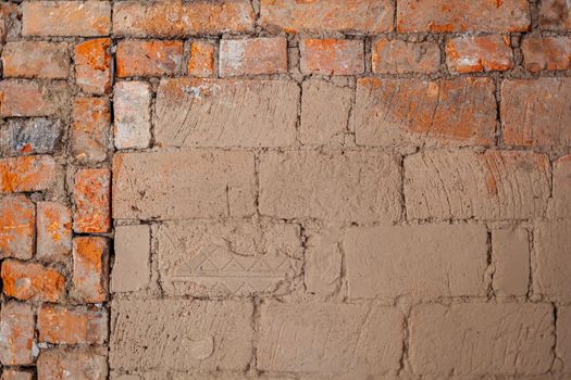 Repair of an old brick wall of a home stove. Different red bricks are laid in the wall after repair. Brick background