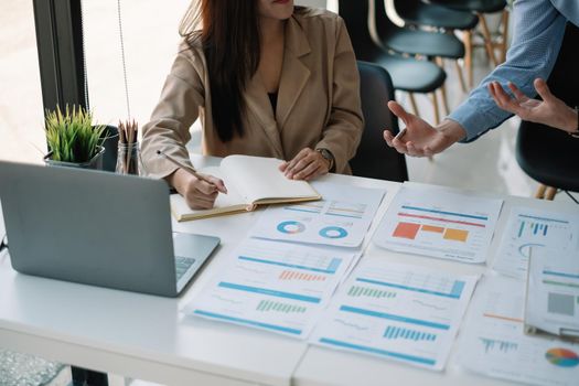 Business Asian People Discussing with coworker planning analyzing financial document data charts and graphs in Meeting and successful teamwork Concept.