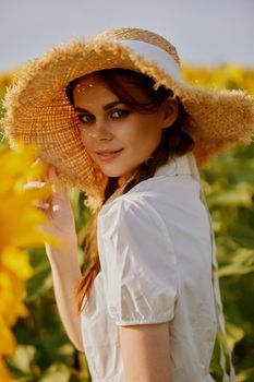 woman with two pigtails looking in the sunflower field landscape. High quality photo